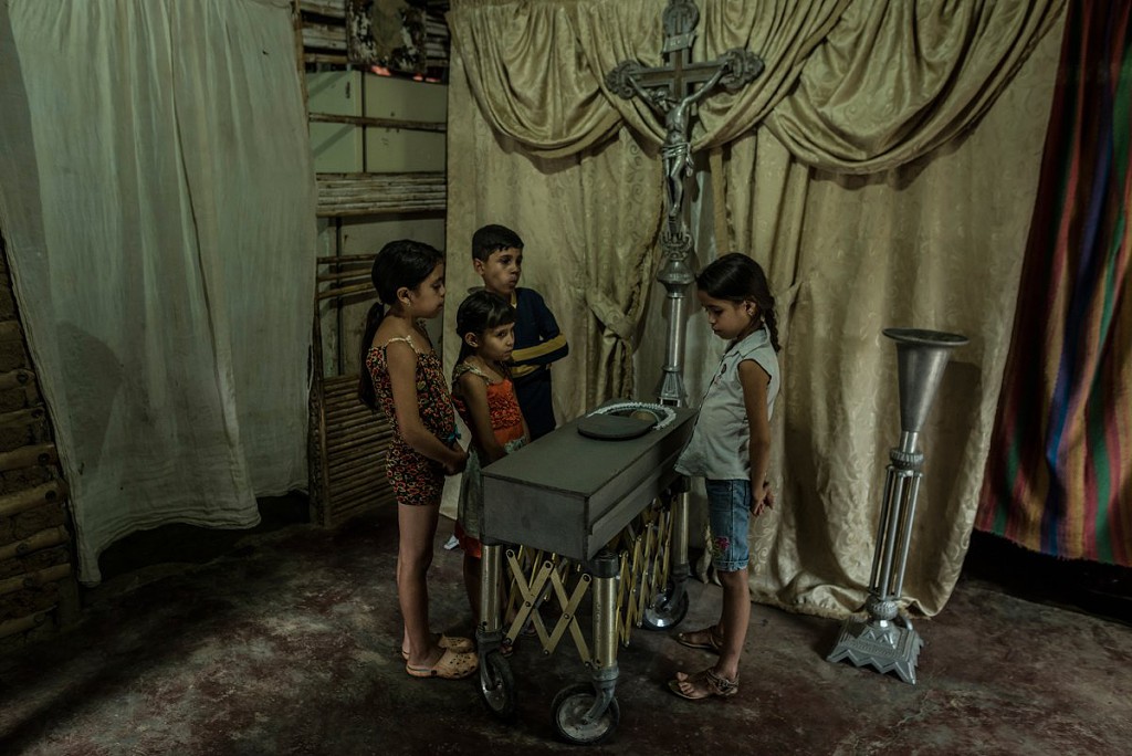 Children view the body of their 17-month old cousin, Kenyerber Aquino Merchán, who died of heart failure caused by severe malnutrition, in San Casimiro, Venezuela, on Aug. 21..jpg